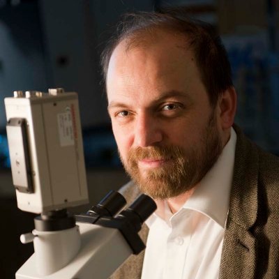 Picture of Prof. Matthias F. Schneider in front of a microscope